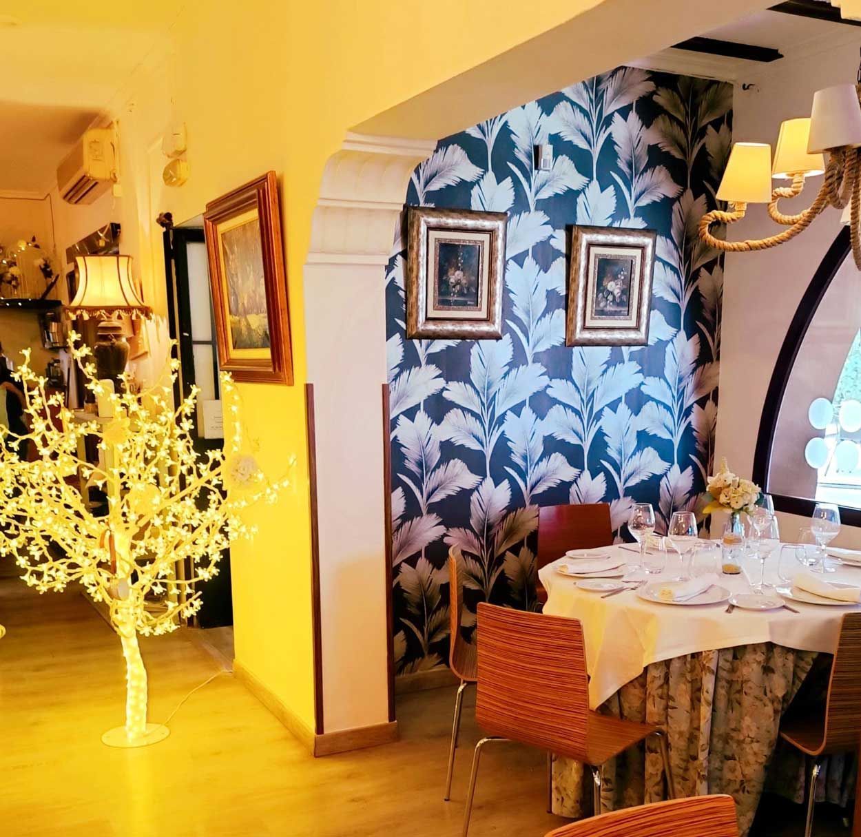 Un comedor con una mesa y sillas y un árbol.