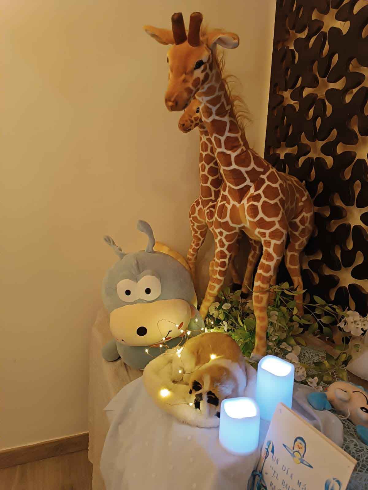 Una mesa con animales de peluche y velas encima.
