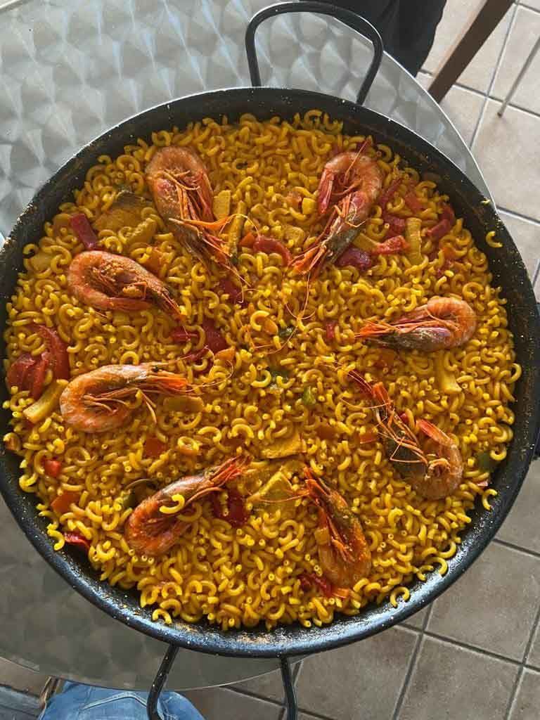 Una sartén de arroz con camarones y verduras sobre una mesa.