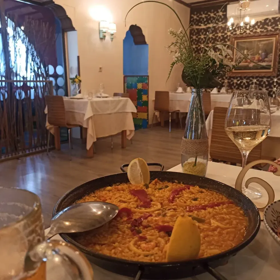 Una sartén con comida reposa sobre una mesa en un restaurante.