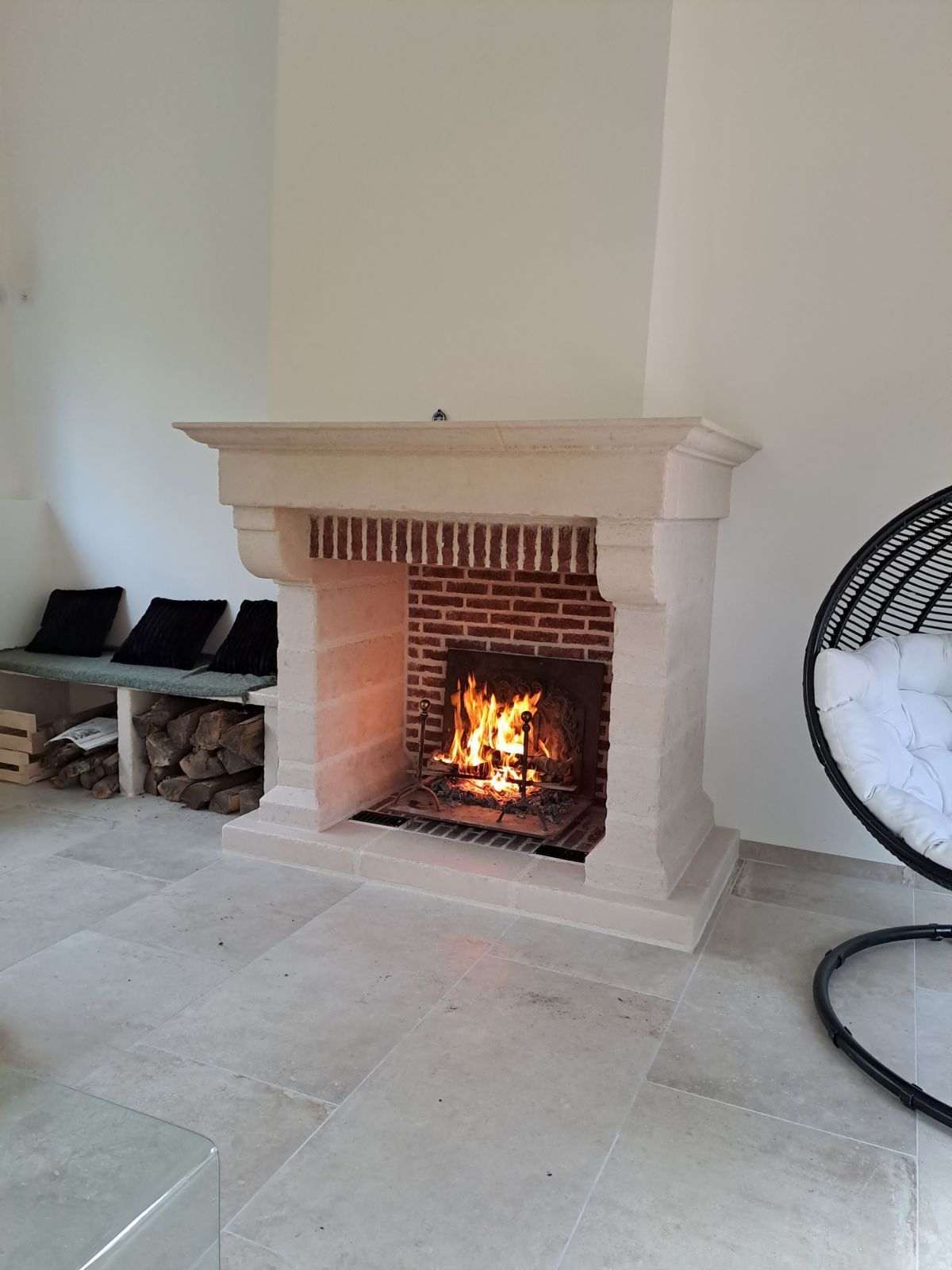 Cheminée allumée en pierre et brique