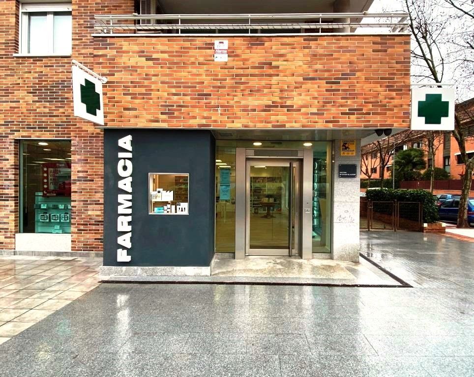 Un edificio de ladrillos con un cartel que dice farmacia.