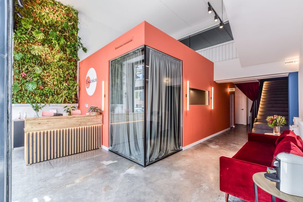 Una sala de estar con un sofá rojo y una pared roja.