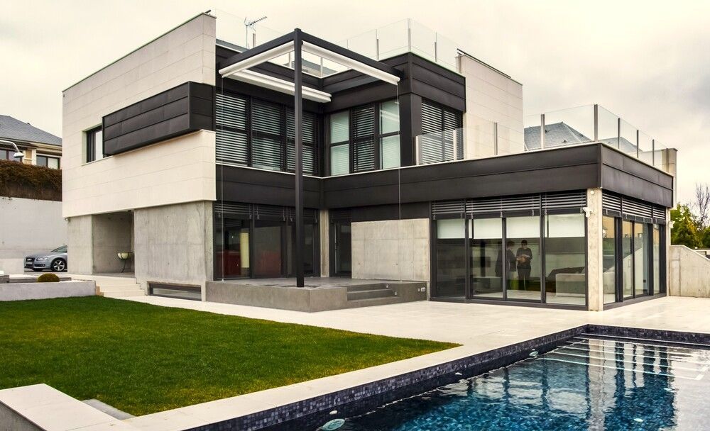 Una casa moderna con piscina delante de ella.