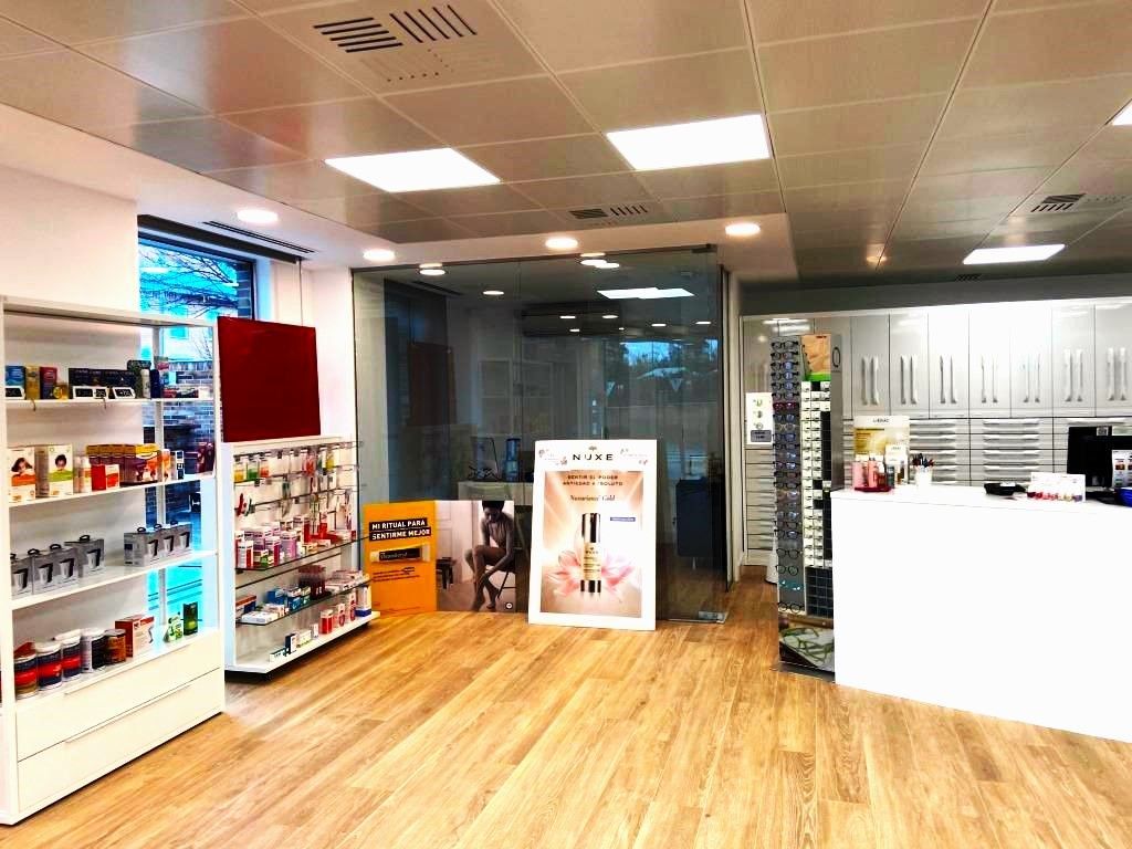 Una farmacia con muchos estantes y un mostrador.