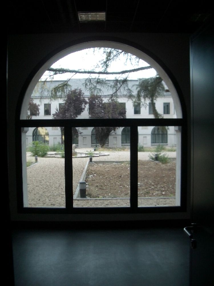 Una vista de un edificio a través de una ventana con marco negro.
