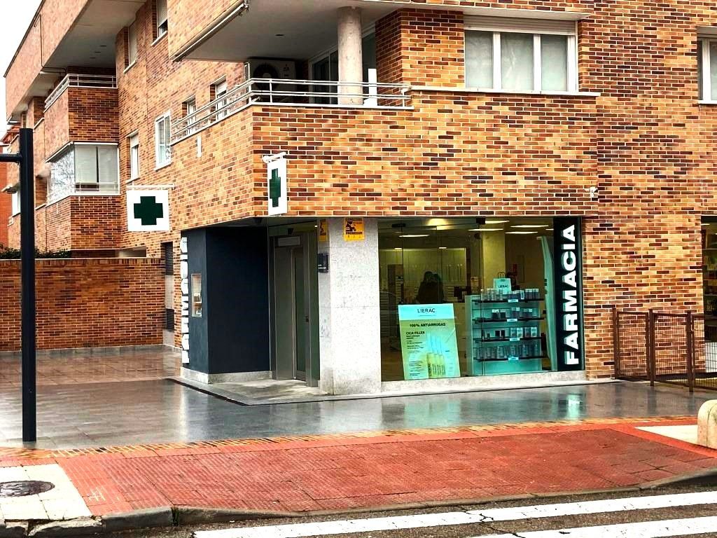 Un edificio de ladrillo con una farmacia al costado.