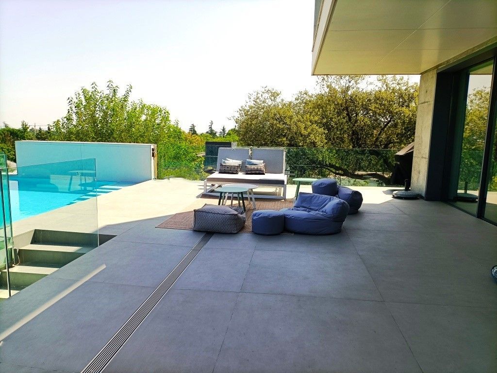 Un gran patio con una piscina al fondo.