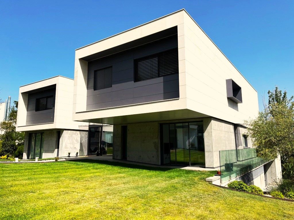 Una casa moderna con un amplio jardín delante de ella.