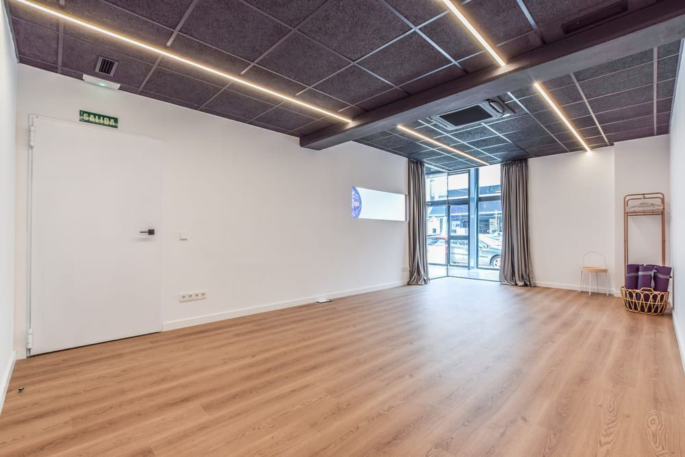 Una gran habitación vacía con suelos de madera y paredes blancas.