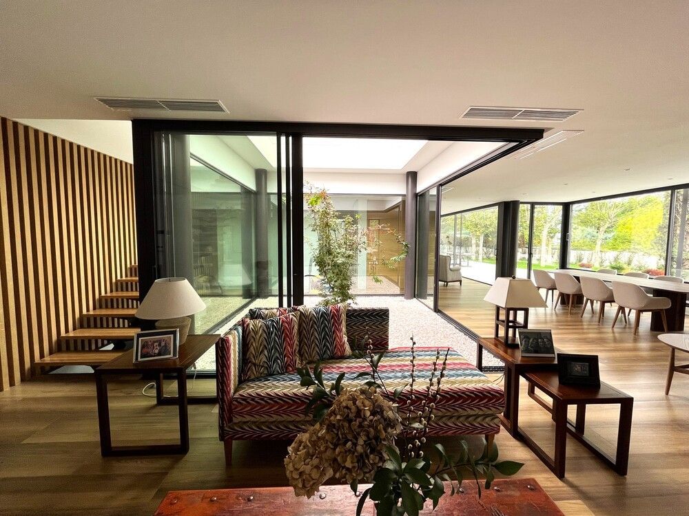 Una sala de estar con un sofá, una mesa, lámparas y un jarrón de flores.