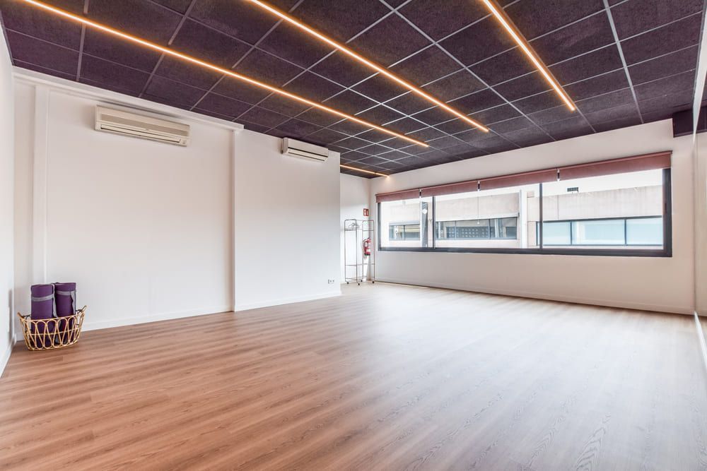 Una gran habitación vacía con suelo de madera y techo morado.