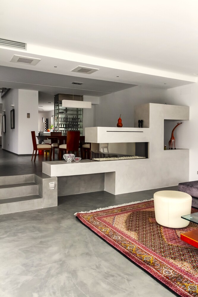 Una sala de estar con chimenea y alfombra.