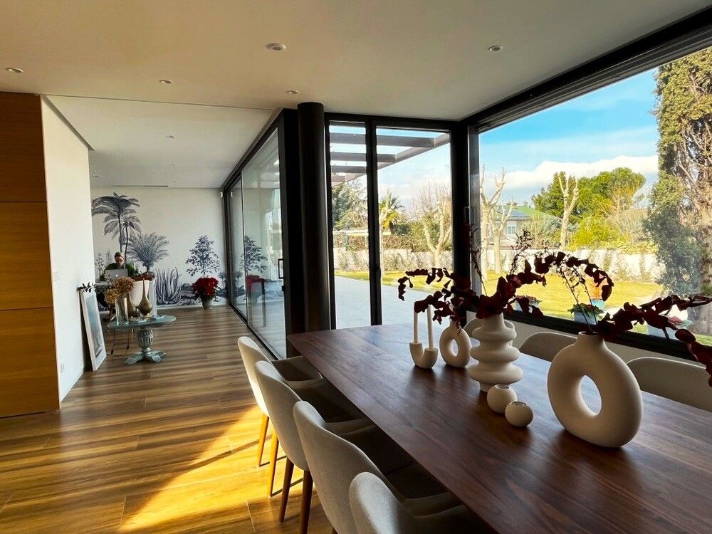 Un comedor con mesa y sillas y una gran ventana.