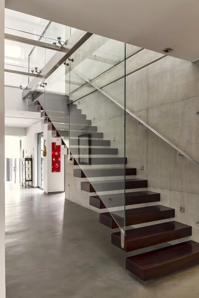 Una escalera moderna con barandilla de cristal en una casa.