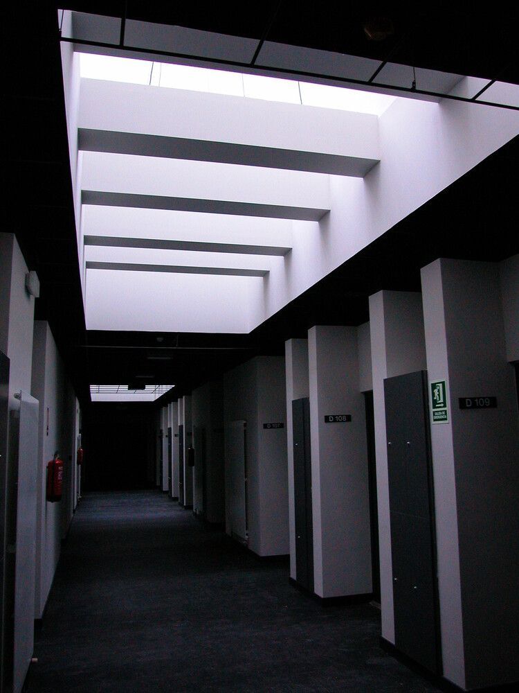 Un pasillo con un cartel verde que dice salida.