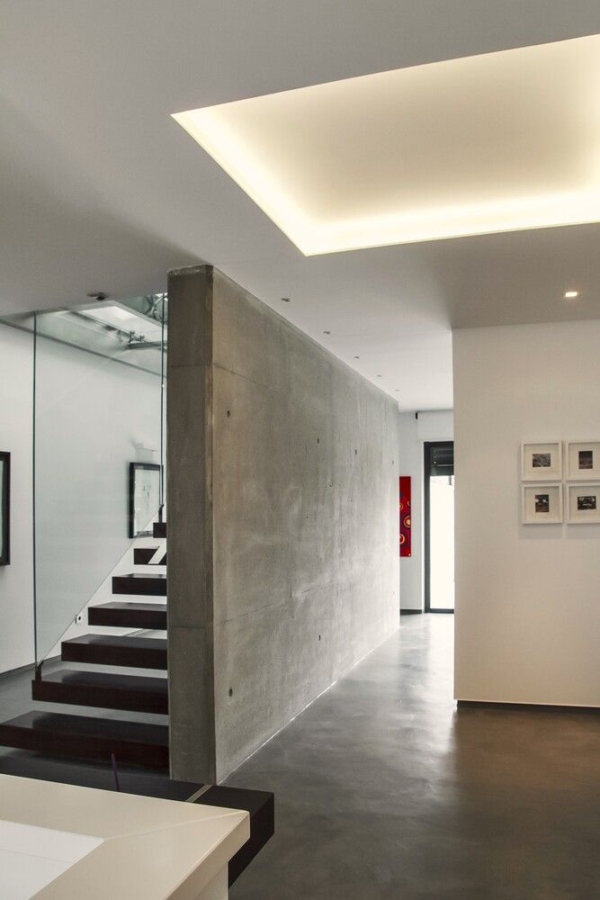 Un pasillo con una escalera y una pared de hormigón.