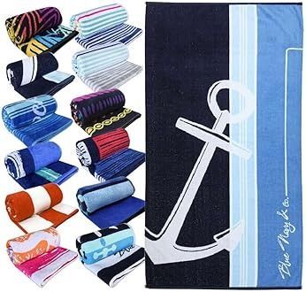 Pila de toallas de playa de colores dobladas junto a una toalla azul marino con un diseño de ancla blanco.