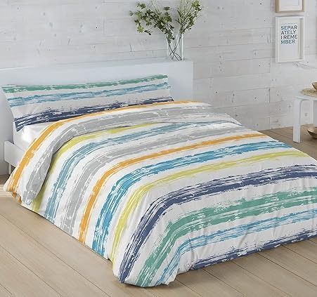 Cama con funda nórdica con rayas coloridas y pictóricas.