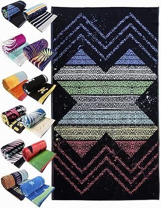 Toalla de playa negra con diseño en zigzag colorido, múltiples toallas enrolladas en varios patrones.