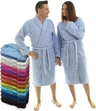 Un hombre y una mujer con batas azul claro, de pie y sonriendo. Junto a ellos, una pila de batas coloridas.