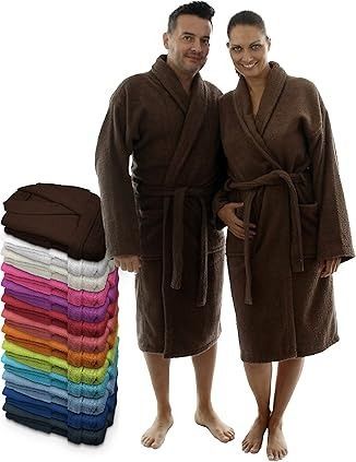 Hombre y mujer vestidos con batas de baño marrones, con túnicas coloridas apiladas.