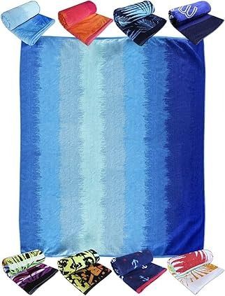 Toalla de playa de color azul con diferentes tonalidades, rodeada de toallas enrolladas de varios colores y estampados.