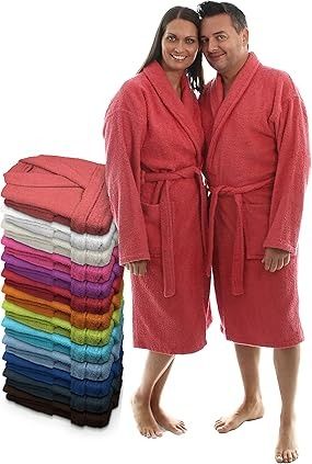 Pareja con túnicas rosas, junto a una pila de batas de baño coloridas.