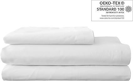 Sábanas blancas cuidadosamente apiladas, con etiqueta de certificación OEKO-TEX Standard 100.