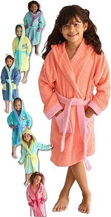 Una niña con una bata coral, sonriendo, posa con otros niños que visten albornoces con capucha de colores.