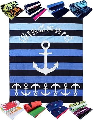 Toalla de playa con diseño de ancla y varias toallas enrolladas más pequeñas de diferentes diseños.