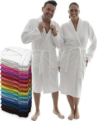 Hombre y mujer con batas blancas; túnicas coloridas apiladas junto a ellos.