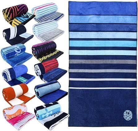 Toallas de playa en varios colores y estampados, enrolladas y apiladas; toalla individual de rayas azules.