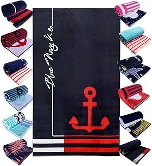 Toalla de playa de color azul marino con ancla roja, rodeada de toallas enrolladas con rayas y estampados.