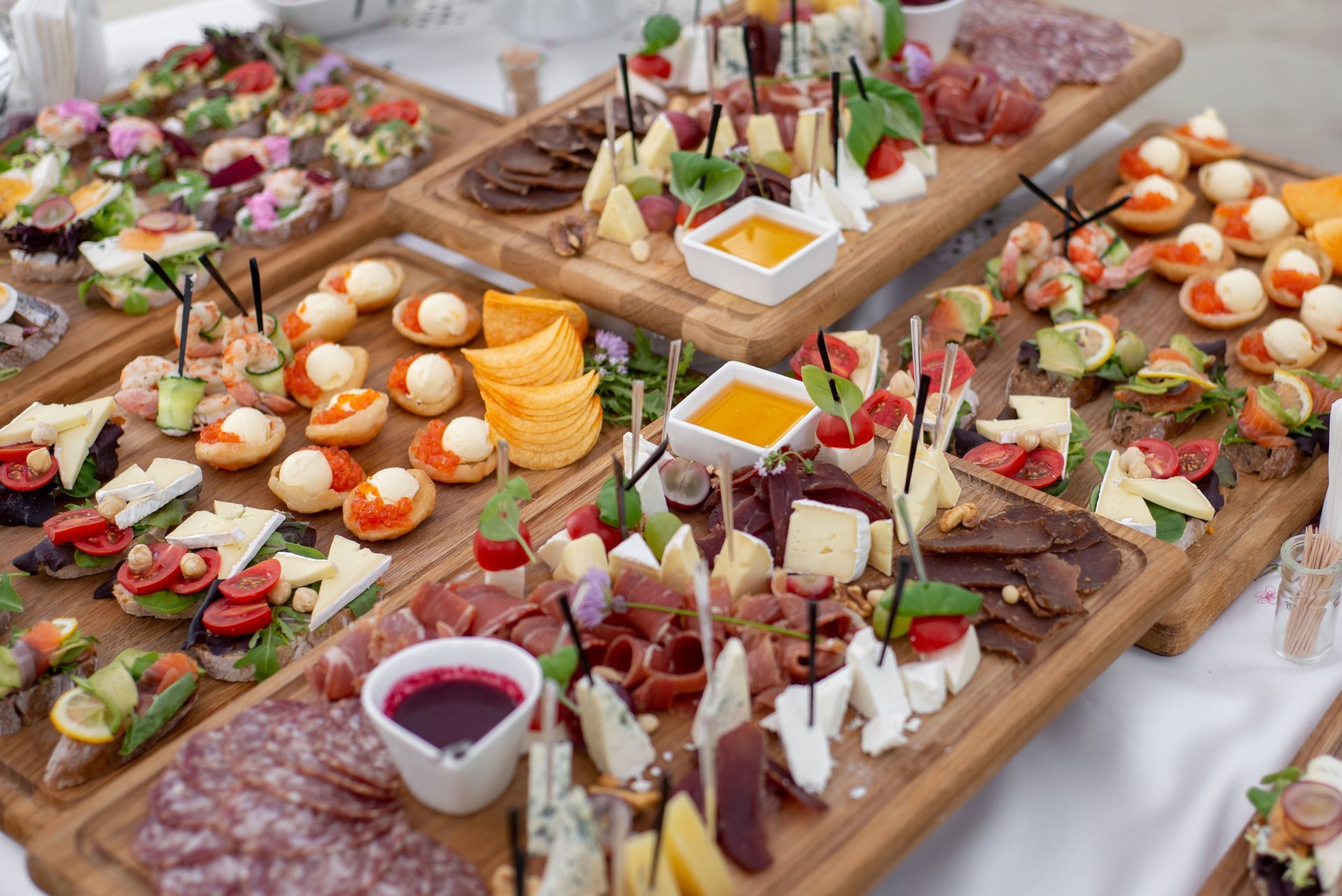 Élégant buffet d'amuse-gueules avec brochettes, pâtisseries, fromages, fruits et sauces présentés sur des planches en bois