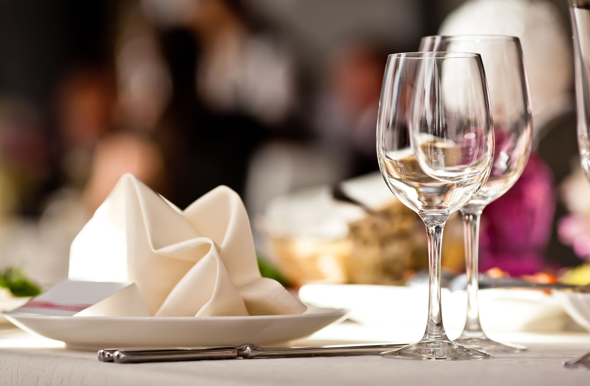 Table élégamment dressée avec serviette blanche pliée et verres à vin lors d'un événement formel
