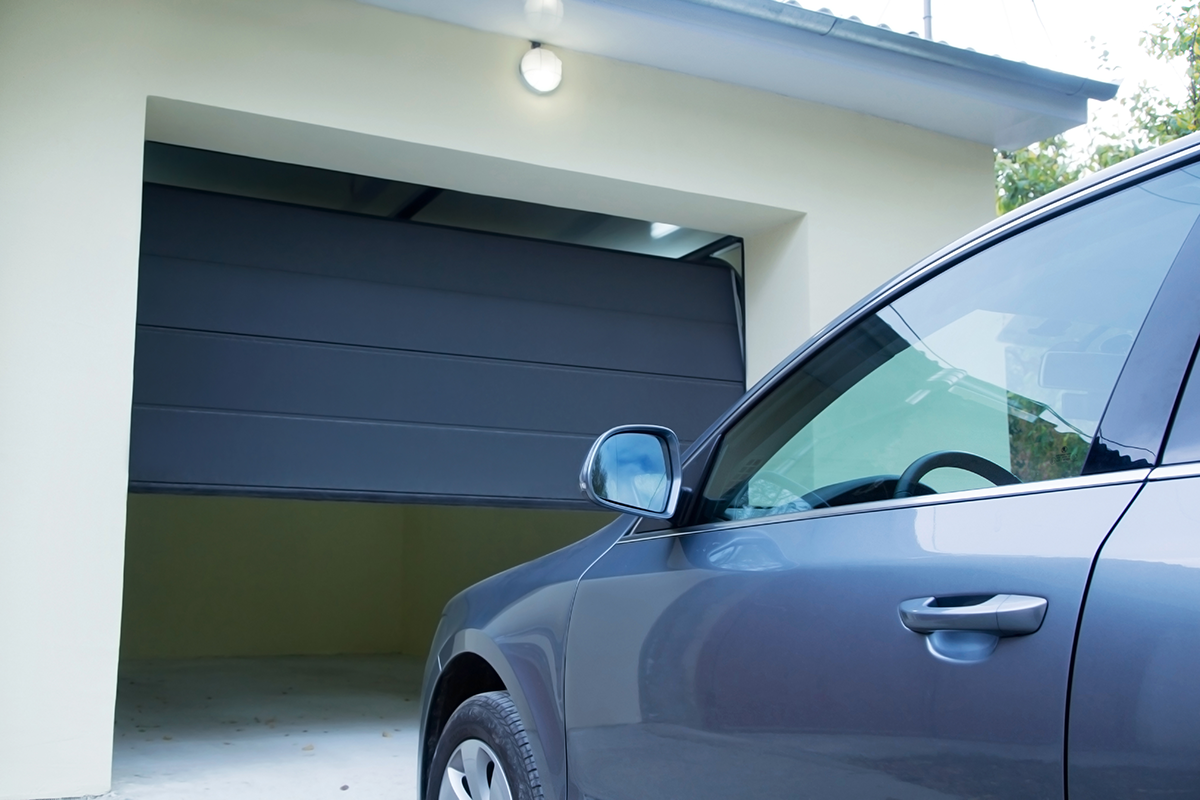 Voiture devant une porte de garage entrouverte