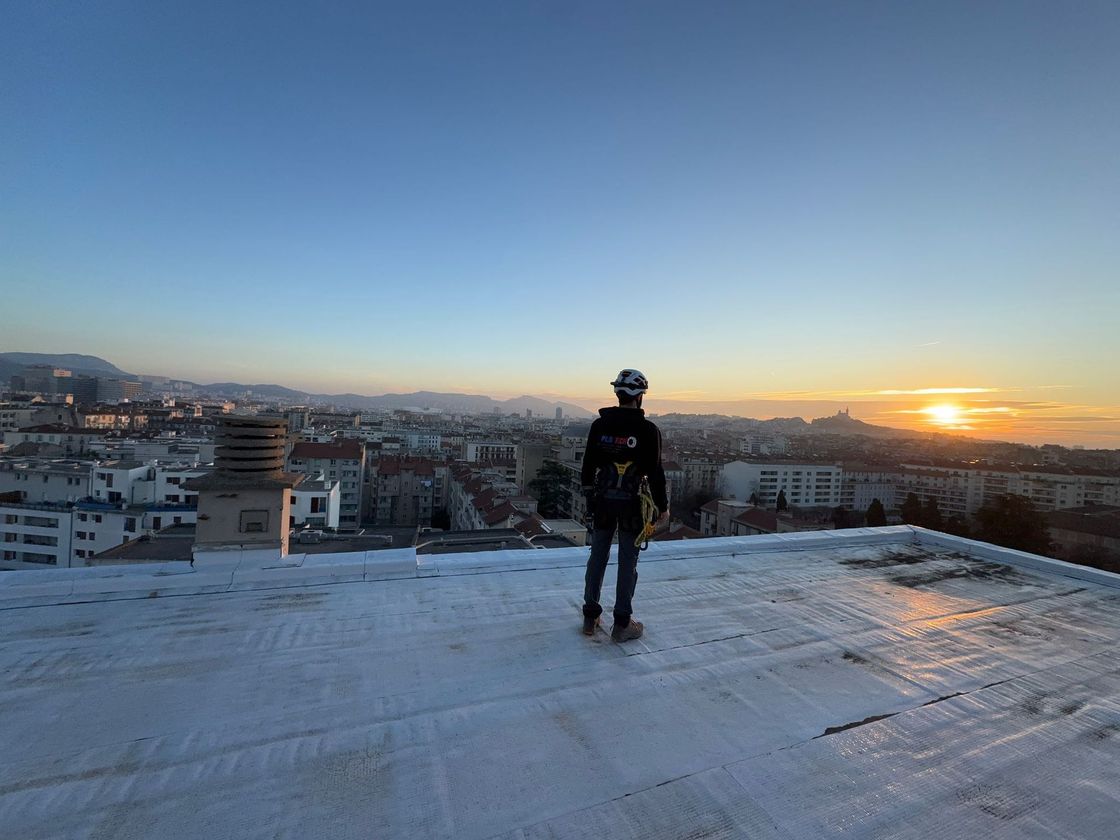 Artisan debout sur un toit avec un coucher de soleil