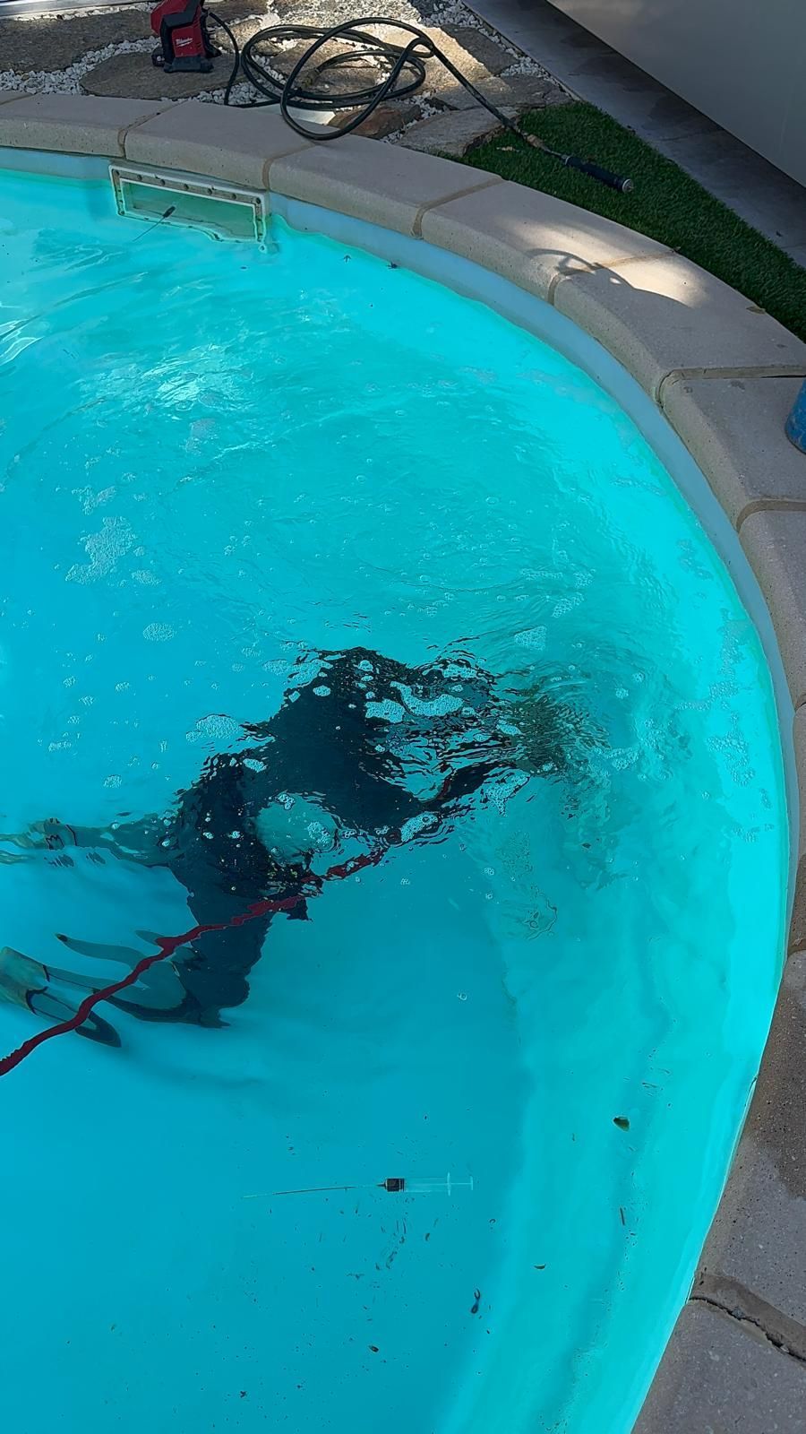 Plongeur en combinaison qui inspecte une piscine