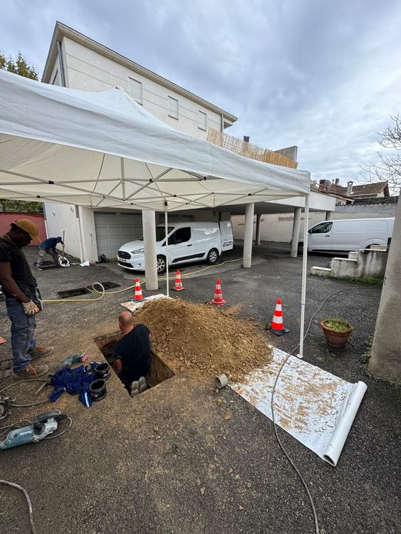 Artisans qui réparent une fuite dans un trou