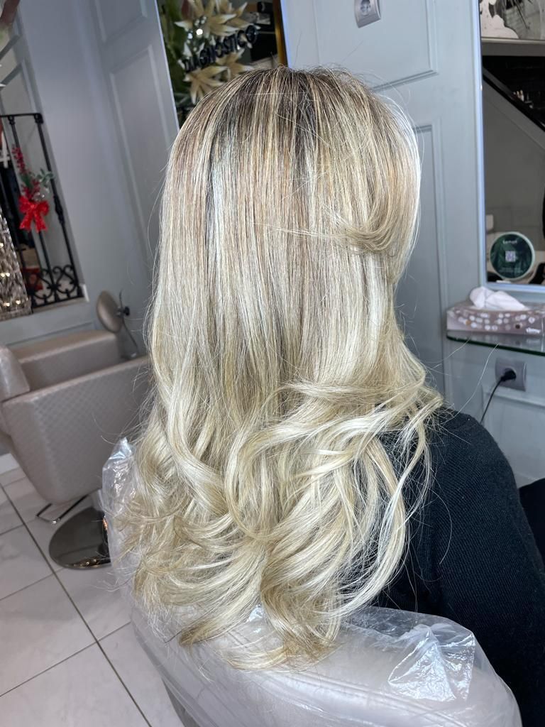 Cabello rubio capeado con rizos sueltos en una silla de peluquería, vista trasera.