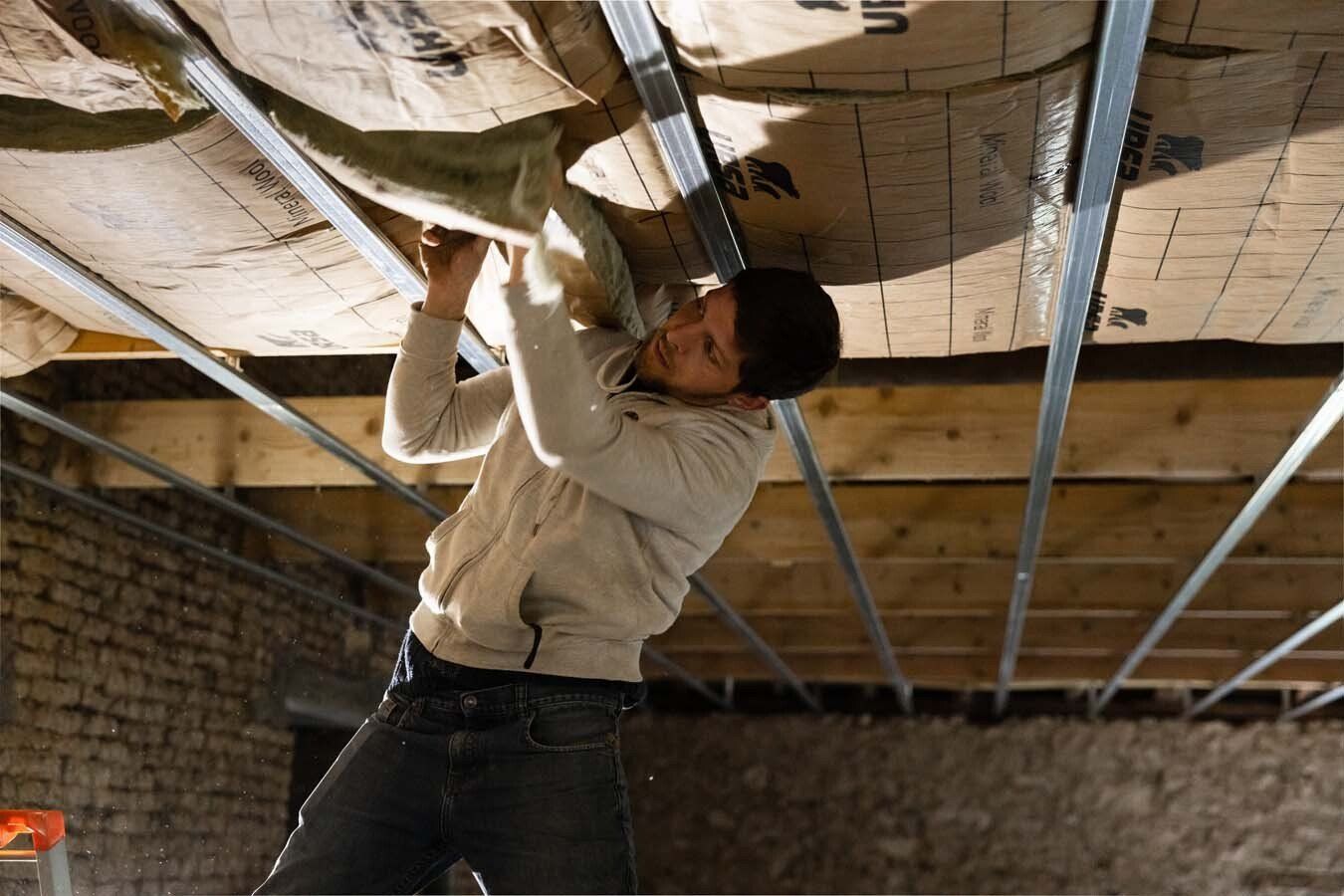 Professionnel installant de l'isolant dans une armature métallique