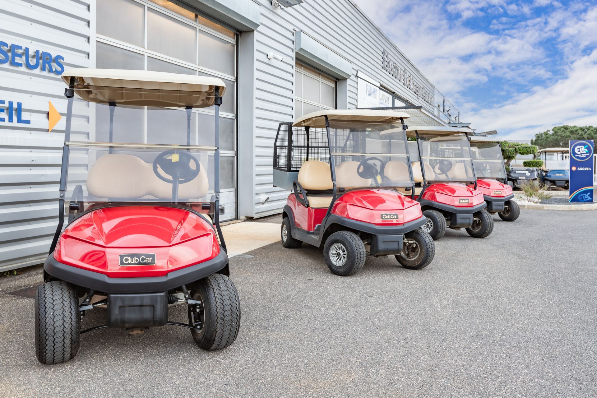 Quatre golfettes rouges devant l'entreprise EBC.