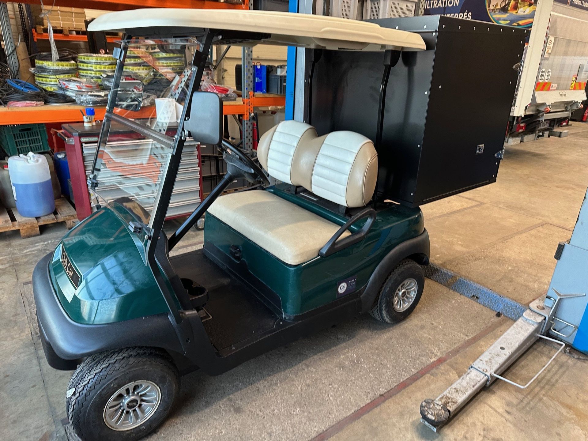 Golfette verte avec coffre à l'arrière.
