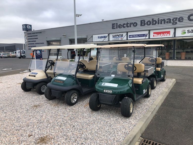 Plusieurs golfettes sur des graviers.