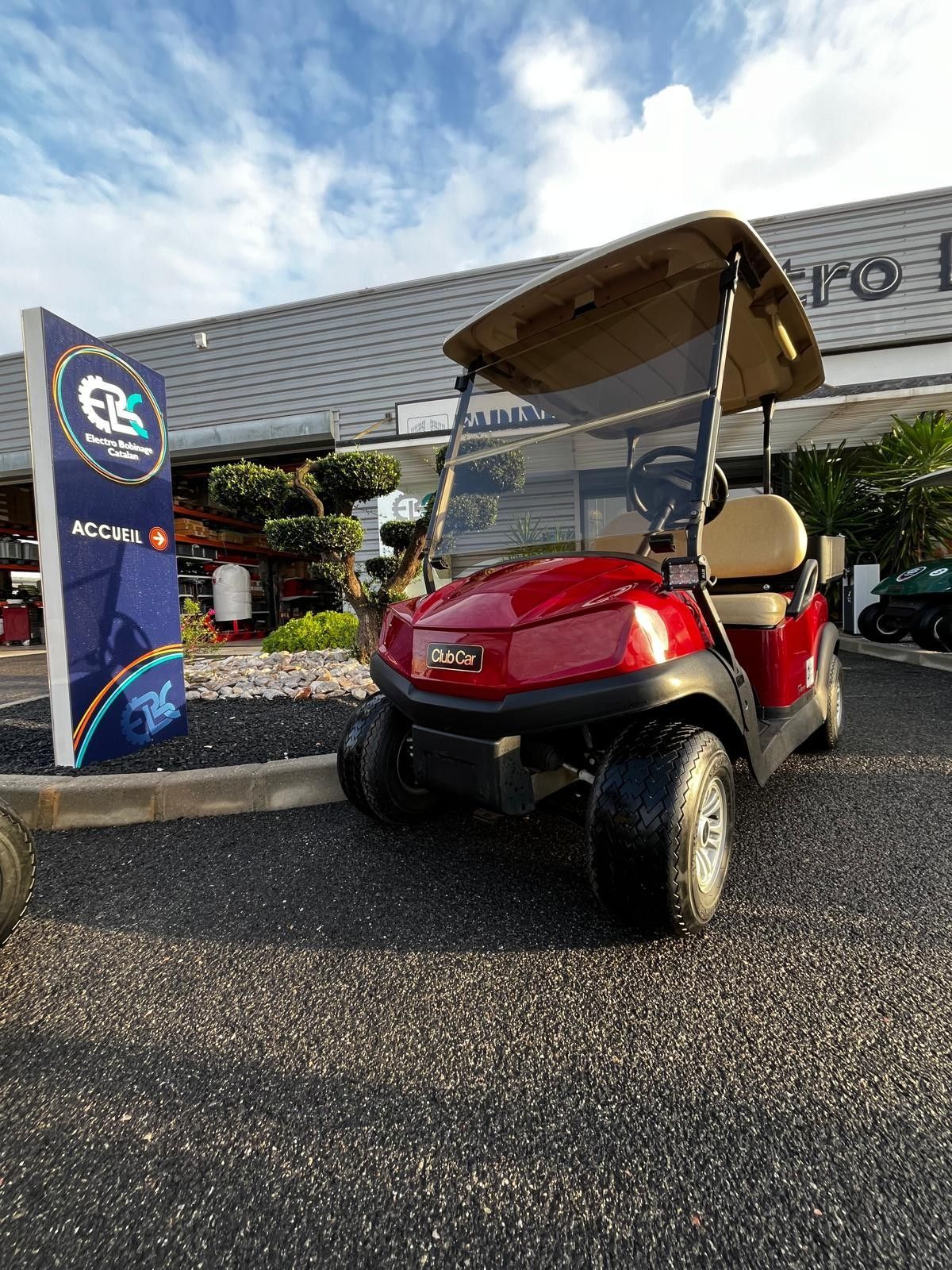 Golfette rouge devant le magasin.