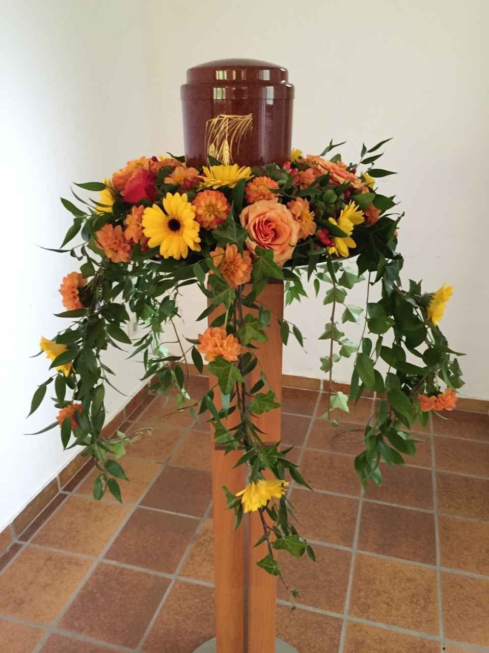 Dunkelrote Urne mit Verzierung auf Blumenschmuck