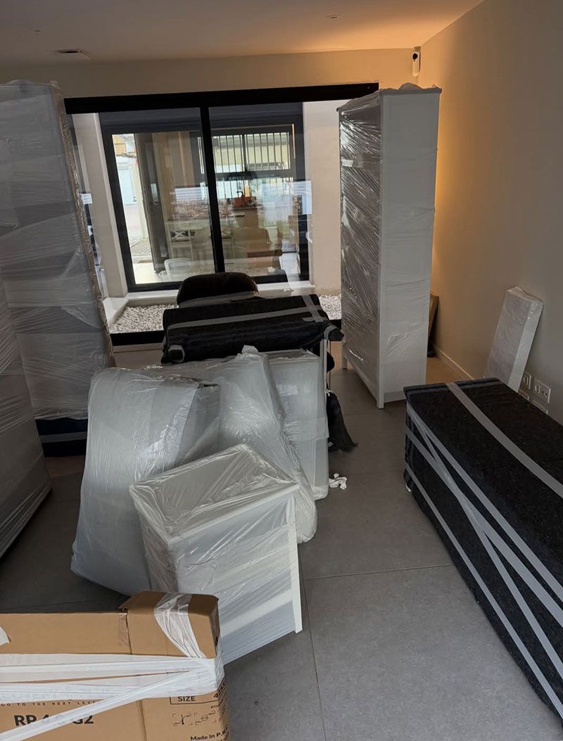 Sala de estar repleta de muebles embalados y cajas durante una mudanza o reforma.