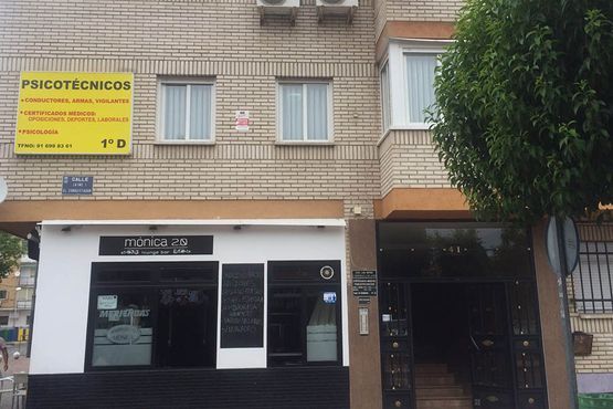 Fachada de un edificio de ladrillo beige con un letrero