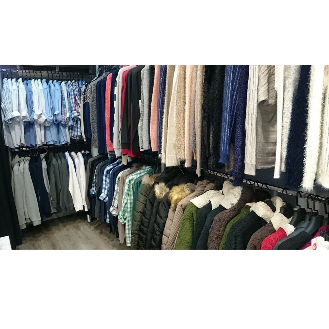 Una tienda llena de ropa colgada en perchas.